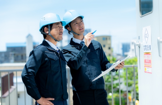 経営理念「行動方針」のイメージ。ヘルメットを着用した作業員が現場で指差し確認を行っている様子。